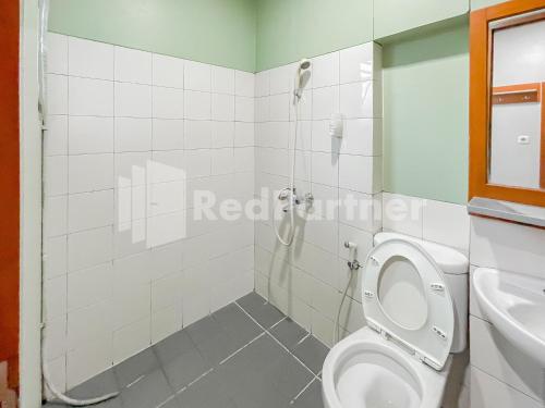 a bathroom with a shower and a toilet and a sink at Sang Surya GuestHouse Syariah Near RS Hasan Sadikin Mitra RedDoorz in Bandung