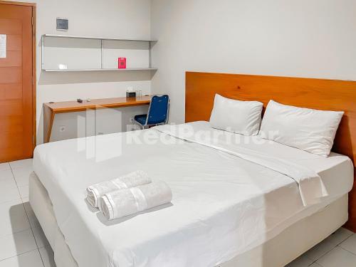 バンドンにあるSang Surya GuestHouse Syariah Near RS Hasan Sadikin Mitra RedDoorzのベッドルーム(白い大型ベッド1台、青い椅子付)
