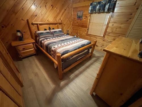 a bedroom with a bed in a wooden cabin at Smoky Mountain Enchanting Haven 3BR2BA Cabin in Sevierville