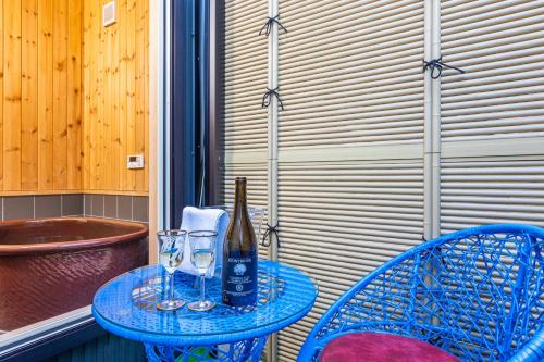 a blue table with a bottle and glasses on it at HP House Shirahama in Shirahama