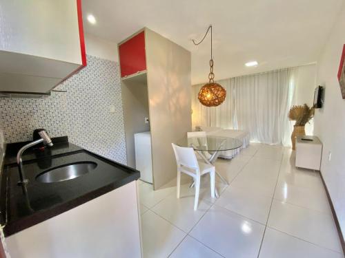uma cozinha com um lavatório e uma mesa num quarto em Bangalô Villas do Pratagy 1 Dormitório e Varanda em Maceió