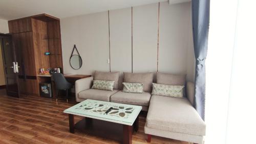 a living room with a couch and a table at HO TRAM GOLDEN HOTEL in Thuận Biên