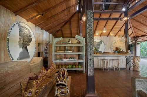 烏布的住宿－Joglo Organik Guesthouse，大房间设有厨房和带椅子的柜台