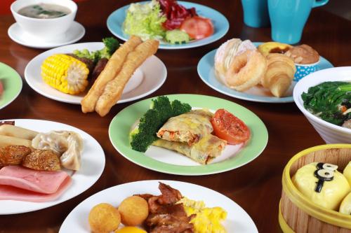 a wooden table with plates of food on it at Four Points by Sheraton Heyuan Resort in Heyuan