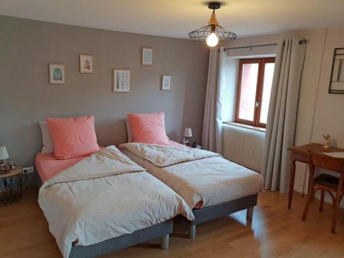 Un dormitorio con una cama con almohadas rosas y una ventana en Guestroom Ventron, 1 pièce, 3 personnes - FR-1-589-567, en Ventron
