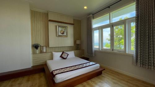 a bedroom with a bed and a large window at Villa Mui Ne Phan Thiet SeaView in Mui Ne