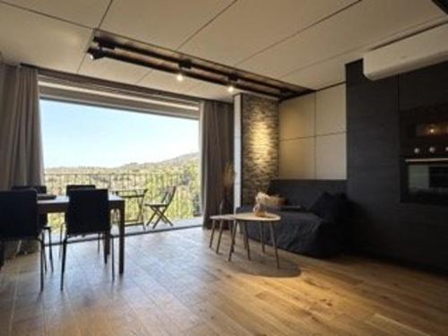 un salon avec une table et une grande fenêtre dans l'établissement Appartement lumineux 6 couchages, 3 pièces, parking, rénové, à 300m de la plage - FR-1-225C-131, à Banyuls-sur-Mer