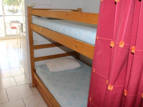 - deux lits superposés avec un rideau rouge dans l'établissement Appt 2P cabine, 6 couchages avec piscine et parking à Gruissan, près plage et port - FR-1-229-868, à Gruissan