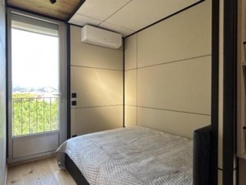 une chambre avec un lit et une grande fenêtre dans l'établissement Appartement lumineux 6 couchages, 3 pièces, parking, rénové, à 300m de la plage - FR-1-225C-131, à Banyuls-sur-Mer
