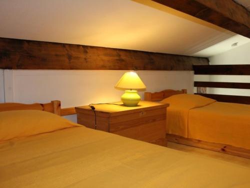 - une chambre avec 2 lits et une lampe sur une commode dans l'établissement Pavillon près plage pour 4 pers. avec terrasse, parking et wifi, animaux acceptés - Gruissan - FR-1-229-869, à Gruissan