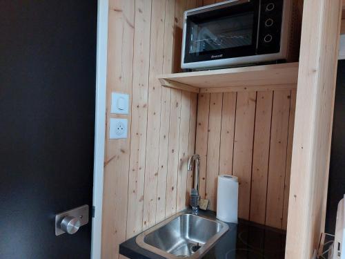 La petite salle de bains est pourvue d'un lavabo et d'un four micro-ondes. dans l'établissement Studio cosy 2 pers, 13m², proche pistes et commerces, Arc 1800 Villards - FR-1-411-894, à Bourg-Saint-Maurice