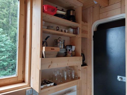 une cuisine avec des étagères en bois et une fenêtre dans l'établissement Studio cosy 2 pers, 13m², proche pistes et commerces, Arc 1800 Villards - FR-1-411-894, à Bourg-Saint-Maurice