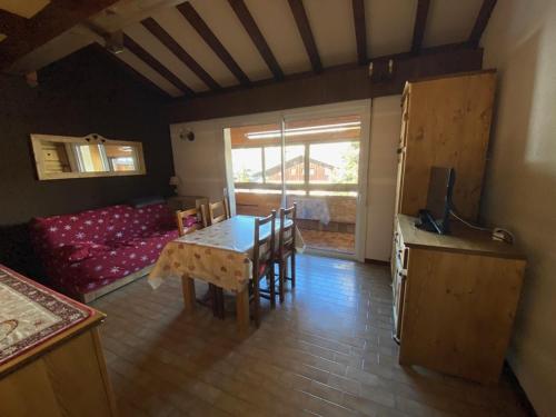 un salon avec une table et un canapé dans l'établissement Appartement 4 personnes, skis aux pieds, centre village avec parking - FR-1-733-135, à Crest-Voland