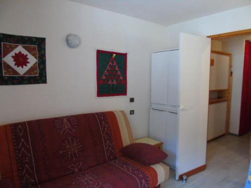 - un salon avec un canapé et un arbre de Noël sur le mur dans l'établissement Studio à Valfréjus près des pistes, balcon ouest, 3 pers - FR-1-561-39, à Valfréjus