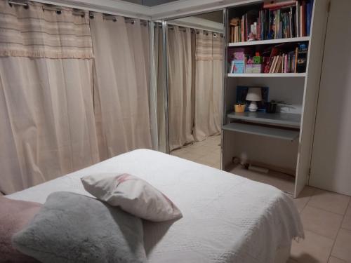 1 dormitorio con 1 cama y estantería con libros en Chambre d'hôte chez Aurélie et Jean-Christophe, en Simpson Bay