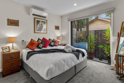 - une chambre avec un grand lit et une grande fenêtre dans l'établissement StayCentral - Thornbury Entertainer Townhouse, à Melbourne