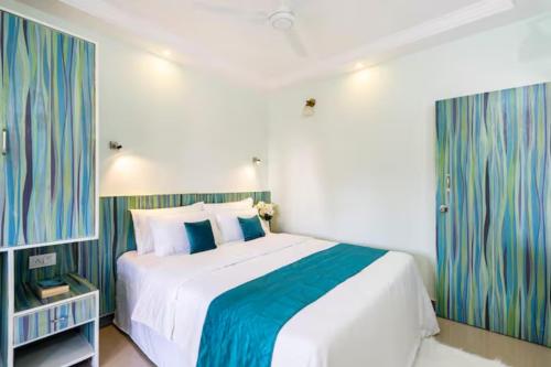 1 dormitorio con 1 cama grande con sábanas azules y blancas en 'Escape to the heavens with our sky view' 1BhK apartment,WIFI, Gym, pool & 5 min walk to Colva Beach, en Colva