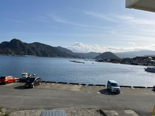 two cars parked in a parking lot next to a body of water at Kitaizu North Private House - Vacation STAY 14216 in Numazu