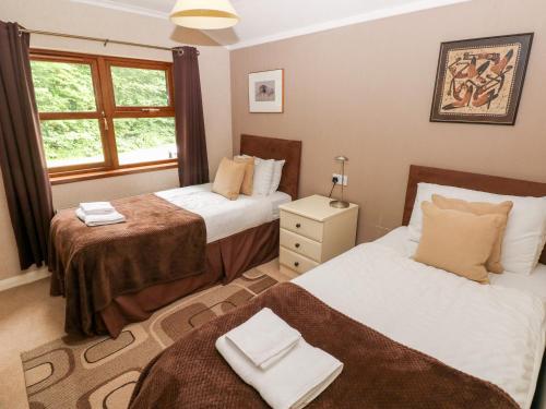 a bedroom with two beds and a window at The Beeches in Narberth