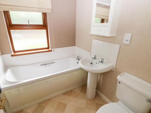 a bathroom with a tub and a sink and a toilet at The Beeches in Narberth