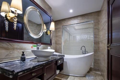 ein Badezimmer mit einer Badewanne, einem Waschbecken und einer Badewanne in der Unterkunft Morninginn, Shuangfeng Platinum Huafu in Shuangfeng
