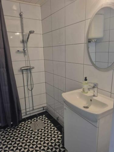 a bathroom with a sink and a shower with a mirror at Rönnås Lada in Tvååker