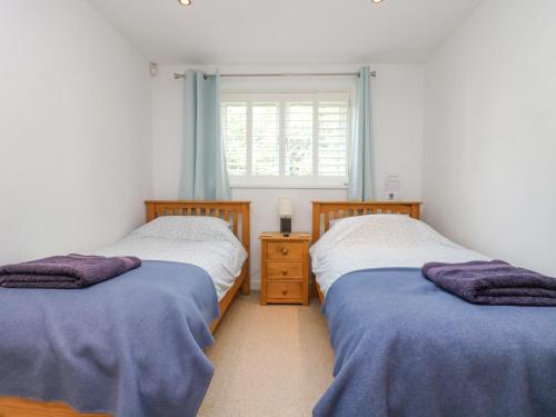 two twin beds in a room with a window at Rock Pool in Downderry