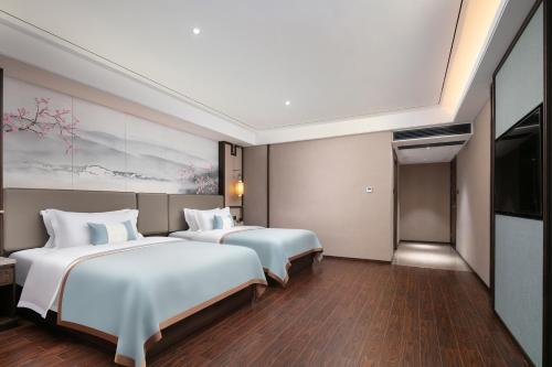 a hotel room with two beds and a tv at Till Bright Hotel, Changsha Provincial Museum in Changsha