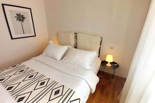 a bed with white sheets and a lamp in a room at Rosa apartment Mirca in Mirce