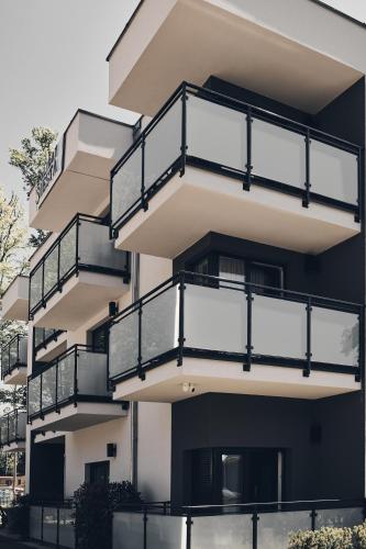 a building with balconies on the side of it at Holiday Siesta Pensjonat, Domki in Rewal