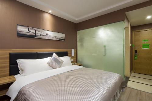 a bedroom with a large bed and a sliding glass door at Morninginn, Radio and Television Center Xianglong Metro Station in Xingsha