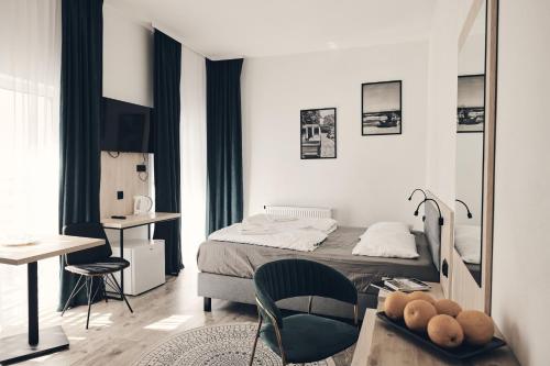 1 dormitorio con 1 cama, 1 mesa y 1 silla en Holiday Siesta Pensjonat, Domki, en Rewal