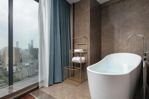 a bathroom with a tub and a large window at Till Bright Hotel, Changsha Provincial Museum in Changsha