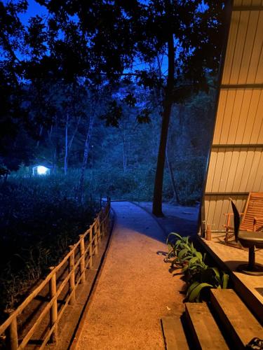 a walkway with a bench next to a fence at night at Pahiyan huts 