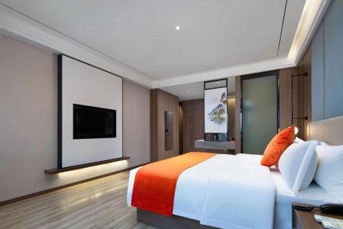 Habitación de hotel con cama y TV de pantalla plana. en Morninginn, Ningbang Plaza Pedestrian Street, en Changsha