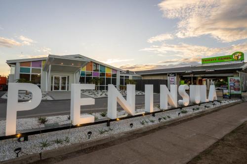 Peninsula Hotel Motel في أديلايد: علامة بيضاء كبيرة أمام متجر