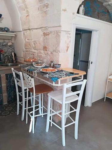 cocina con mesa con sillas y encimera en Casa Zia Menga, en Ceglie Messapica