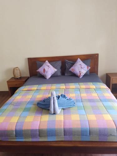 a bed with two pairs of towels on it at Nami House in Ubud