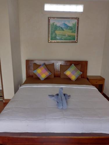 a bedroom with a bed with a blue towel on it at Nami House in Ubud