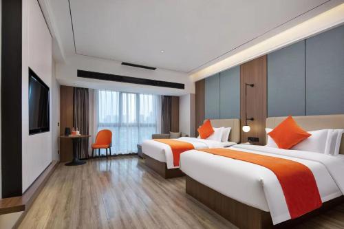 um quarto de hotel com duas camas e uma televisão em Morningup Hotel, Wugang em Wugang