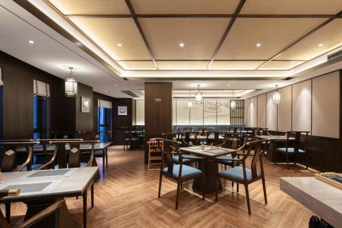 a restaurant with tables and chairs in a room at Till Bright Hotel, Changsha Provincial Museum in Changsha