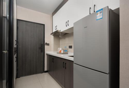 a kitchen with a refrigerator and a counter top at Morninginn, Jingzhu Square in Hengyang