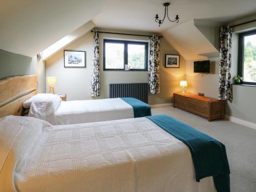 a bedroom with two beds and a tv and two windows at Nevern House in Newport