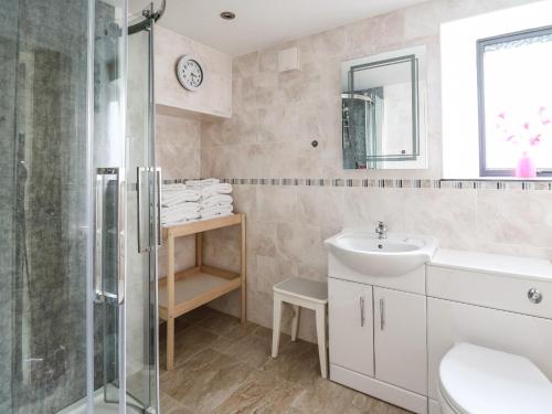 a bathroom with a shower and a sink and a mirror at Nevern House in Newport