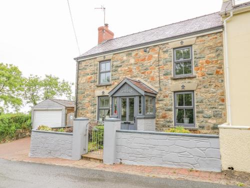 an old stone house with a fence in front of it at Greenbanks in Newport