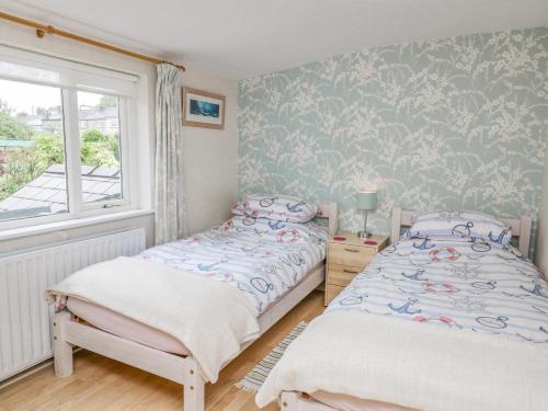 a bedroom with two twin beds and a window at Greenbanks in Newport Pembrokeshire