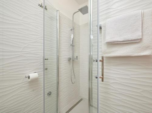 La salle de bains est pourvue d'une douche avec une porte en verre. dans l'établissement Guesthouse Ana Trogir Old Town, à Trogir