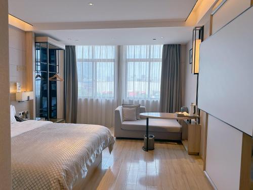 a hotel room with a bed and a chair and window at Morning Hotel, Changsha Langli in Changsha