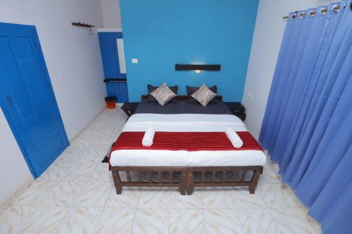 1 dormitorio con 1 cama grande y paredes azules en Sky Frame Beach Resort, en Varkala