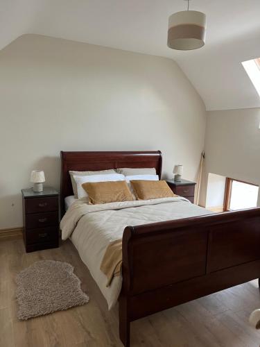 1 dormitorio con 1 cama grande y 2 mesitas de noche en Tom Rocky’s Farmyard, en Templemore